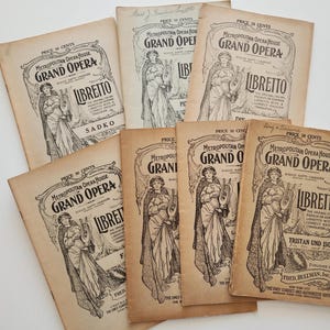 May include: A collection of vintage Metropolitan Opera House librettos. The covers feature an illustration of a woman with a harp, and the text "Grand Opera" and "Libretto". The librettos are printed in black ink on aged paper.