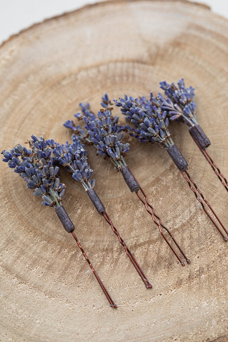 Pode incluir: Cinco grampos de cabelo de lavanda com hastes de fio de cobre. A lavanda est&aacute; seca e disposta em um cacho no topo de cada grampo.