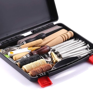 May include: A black plastic case filled with leatherworking tools, including needles, thread, awls, and a hammer. The case has a red latch.