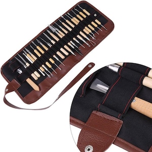 Könnte beinhalten: Eine aufrollbare Tasche aus braunem Kunstleder mit einem Set aus Modellierwerkzeugen mit hellen Holzgriffen und Metallspitzen. Das Innere verfügt über schwarze elastische Schlaufen zur Befestigung der Werkzeuge und einen Riemen mit Druckknopf.
