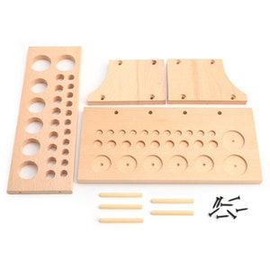 May include: A wooden organizer with multiple compartments for storing small items. The organizer has a variety of round holes and slots of different sizes. It comes with four wooden dowels and black screws for assembly.