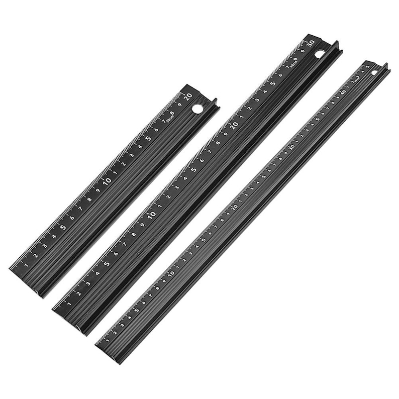May include: Three black metal rulers with markings in inches and centimeters. The rulers are 20 inches, 30 inches, and 40 inches long.