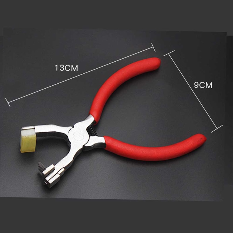 May include: Red handled metal punch tool with a 13 cm length and 9 cm width. The tool is used for punching holes in leather or other materials.