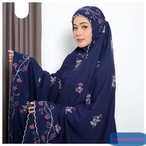 May include: A navy blue prayer shawl with a floral embroidery design. The shawl has a scalloped edge and features pink and white flowers.