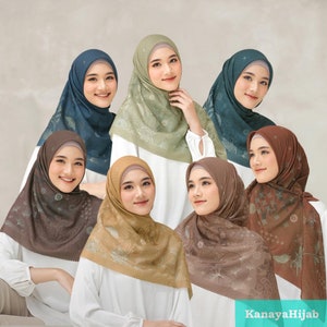 Op de afbeelding: Een collectie van zeven hijabs in verschillende kleuren, waaronder blauw, groen, bruin en beige. Elke hijab heeft een bloemenpatroon en is over het hoofd en de schouders gedrapeerd. De afbeelding bevat de tekst "KanayaHijab".