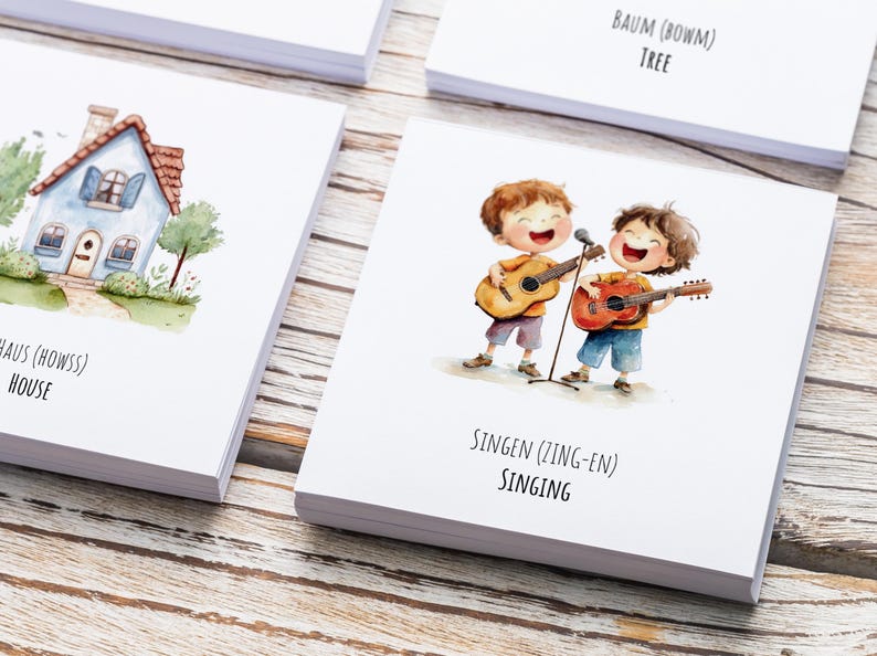 May include: Two children with brown hair are singing and playing acoustic guitars. The text on the card reads "SINGEN (ZING-EN) SINGING".