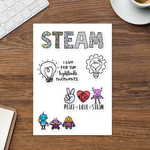 May include: A set of colorful stickers with a STEAM theme. The stickers feature robots, lightbulbs, hearts, and the word "STEAM". The text "I live for the lightbulb moments" is also included on one of the stickers.