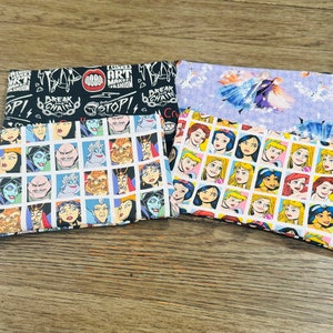 May include: Three fabric pouches with different designs. The top pouch is black with white text that reads "FLIRKS ART MAKES FASHION" and "BREAK THE CHAIN". The middle pouch is light purple with a white silhouette of a princess in a blue dress. The bottom pouch is white with a grid of colorful cartoon images of princesses.