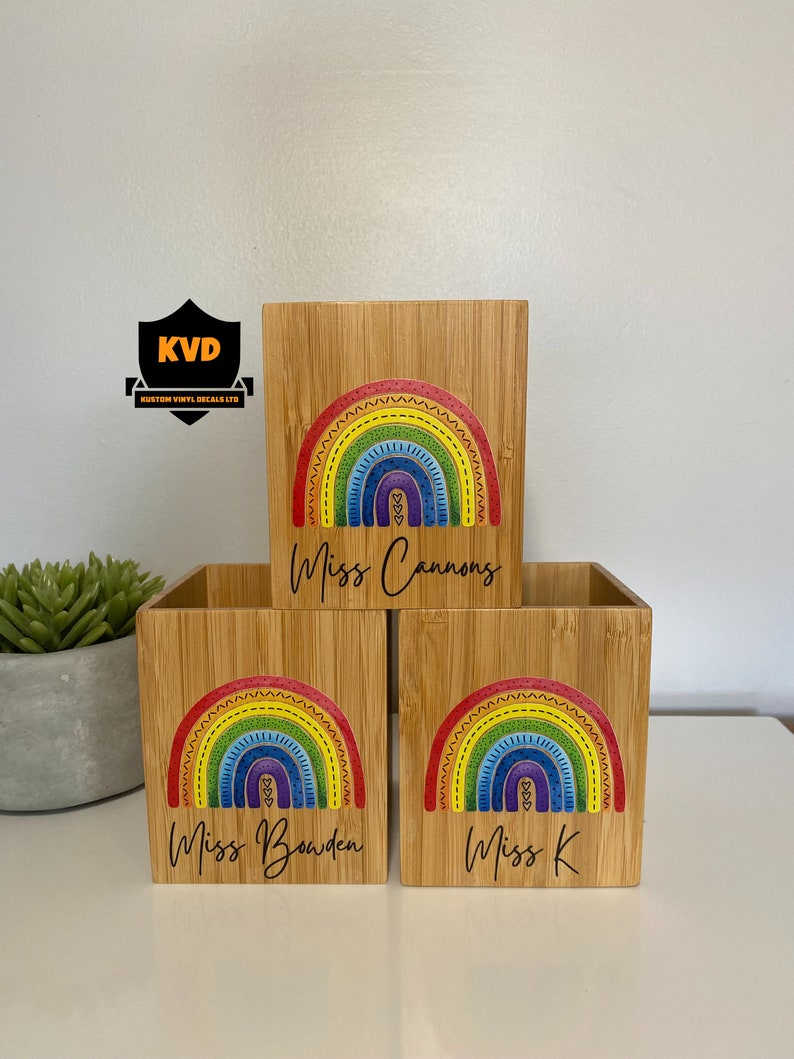 Pu&ograve; includere: Tre portapenne in bamb&ugrave; con un colorato design arcobaleno. Ogni portapenne ha un nome diverso: Miss Cannons, Miss Bowden e Miss K. L'arcobaleno presenta colori rosso, arancione, giallo, verde, blu e viola.