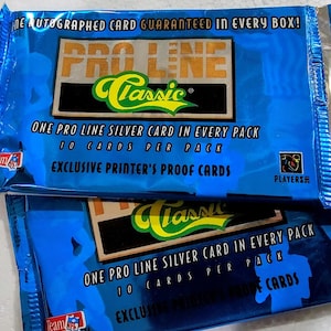 May include: Two blue Pro Line Classic trading card packs. Each pack features text that reads "One Pro Line Silver Card in Every Pack" and "Exclusive Printer's Proof Cards". The packs are sealed and have a silver foil interior.
