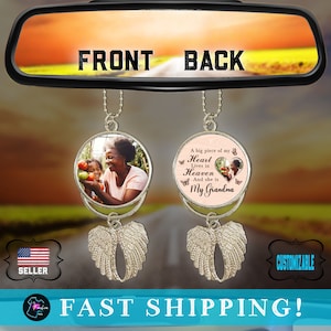 May include: A car charm with two round photo inserts. The front insert features a photo of a woman and a child. The back insert features a pink background with the text "A big piece of my Heart Lives in Heaven And she is My Grandma". Both inserts are attached to silver angel wings.