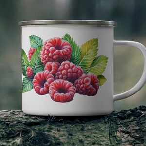 Peut inclure: Mug en émail blanc avec un motif de framboises rouges et de feuilles vertes.
