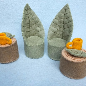 May include: Two green felt leaf-shaped chairs with brown felt seats and two brown felt tree stump tables with yellow felt cups and green felt leaves on top.