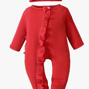 Puede incluir: Un conjunto de ropa de beb&eacute; rojo, que incluye un pelele de manga larga y una diadema a juego. El pelele presenta un ribete con volantes en la parte delantera y una tela de punto texturizada. La diadema tiene un detalle de lazo. El conjunto est&aacute; dise&ntilde;ado para beb&eacute;s.