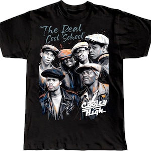 May include: A black short-sleeve t-shirt featuring a graphic print of five individuals wearing caps and jackets. The text "The Real Cool School" appears at the top, and "Cooley High" is printed in white at the bottom right of the illustration.