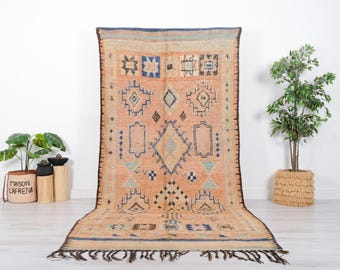 Könnte beinhalten: Ein vintage marokkanischer Teppich mit einem geometrischen Muster in Beige-, Blau- und Brauntönen. Der Teppich hat einen Fransenrand und ist aus Wolle.