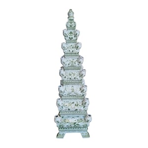 Può includere: Un vaso alto per tulipani in ceramica bianca con un design a più livelli. Il vaso presenta molteplici aperture per fiori ed è decorato con motivi floreali verdi. Il vaso ha una base decorativa e una parte superiore a punta.