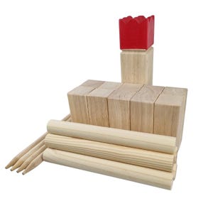 May include: A wooden yard game set with natural wood blocks, dowels, and pointed sticks. A red block sits atop a tower of wooden blocks. The set is designed for outdoor play and family fun.