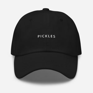 Op de afbeelding: Een zwarte baseballpet met witte geborduurde tekst die "PICKLES" luidt.