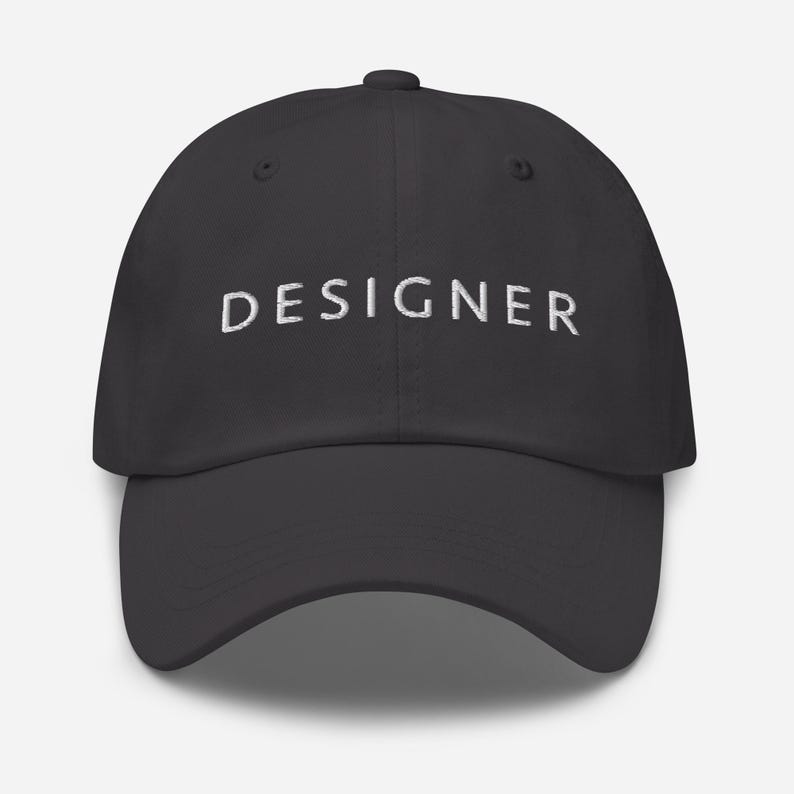 May include: A dark gray baseball cap with the word "DESIGNER" embroidered in white on the front.