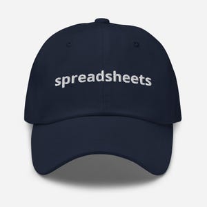 May include: A navy blue baseball cap with white embroidered text that reads "spreadsheets".
