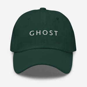 May include: A dark green baseball cap with the word "GHOST" embroidered in white on the front.