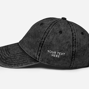 Könnte beinhalten: Eine schwarze, abgenutzte Baseballkappe aus Denim mit weißen Nähten und dem gestickten Text "YOUR TEXT HERE" auf der Vorderseite.