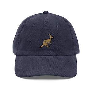 May include: A navy blue corduroy baseball cap with an embroidered kangaroo in gold.