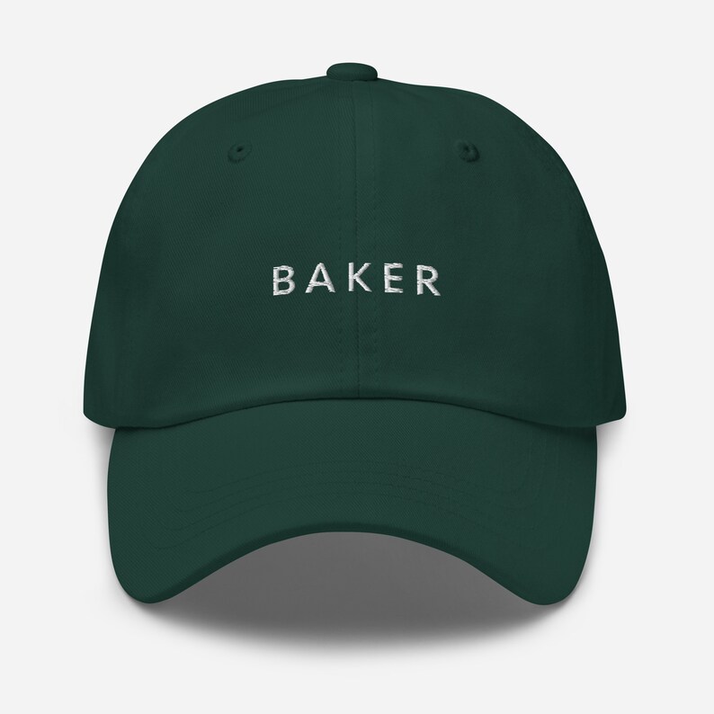 May include: A dark green baseball cap with the word "BAKER" embroidered in white on the front.