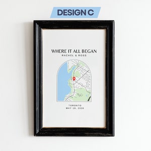 Könnte beinhalten: Ein schwarzer gerahmter Druck mit weißem Hintergrund. Der Druck zeigt eine Karte von Toronto, Kanada, mit einer roten Stecknadel, die einen Ort markiert. Der Text "WHERE IT ALL BEGAN" befindet sich oben auf dem Druck, gefolgt von "RACHEL & ROSS" und "TORONTO MAY 18, 2020".