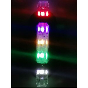 May include: Vertical image of three illuminated, clear, faceted light fixtures. The top fixture glows red, the middle one multi-colored, and the bottom one white. The background is dark, emphasizing the vibrant colors of the lights.