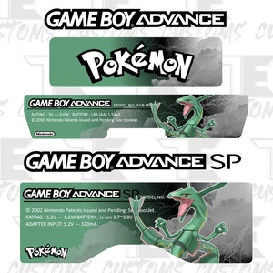 Könnte beinhalten: Ein Satz von drei grünen und schwarzen Aufklebern für einen Game Boy Advance und einen Game Boy Advance SP. Die Aufkleber zeigen das Pokemon-Logo und eine grüne drachenartige Kreatur.