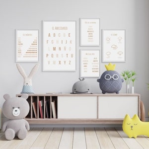 May include: A nursery room with a wooden shelf with books, a gray teddy bear, a gray bunny, a gray pineapple with a crown and glasses, a yellow cat, and five framed posters on the wall. The posters are in Spanish and feature the alphabet, days of the week, months of the year, weather, and numbers.