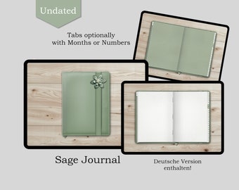 May include: Sage green undated journal with tabs for months or numbers. The journal has a decorative flower on the front cover. The journal is open to a blank page with a grid pattern. The text "Deutsche Version enthalten!" is visible on the bottom of the image.