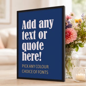 Peut inclure: Un cadre noir rectangulaire contenant une affiche bleu foncé avec du texte blanc indiquant Add any text or quote here! et un texte doré plus petit en dessous indiquant PICK ANY COLOUR CHOICE OF FONTS. L'affiche est orientée verticalement.
