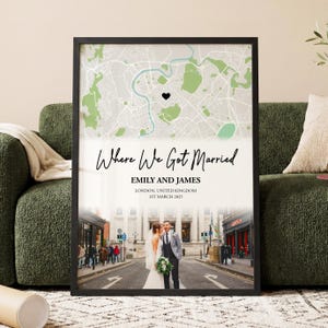 May include: Framed wedding map art print featuring a map of London with a heart marking a location. The text "Where We Got Married" is above the names "Emily and James" and the date "1st March 2025". A photo of a couple is at the bottom.
