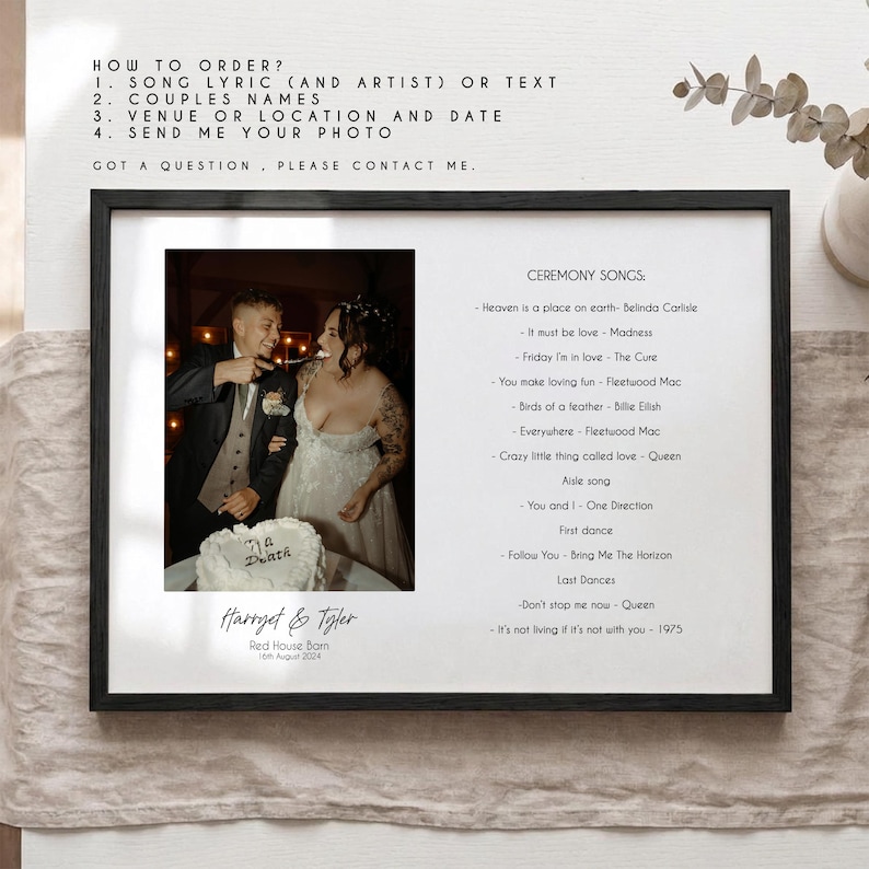 May include: A framed wedding print with a photograph of a couple and their ceremony song lyrics. The black frame encloses a white background with the couple's names, wedding date, and venue. The print also includes a list of songs and ordering instructions.