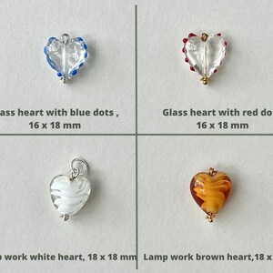 May include: Four glass heart charms with different designs and colors.  The top left charm is clear glass with blue dots, the top right charm is clear glass with red dots, the bottom left charm is white glass with a swirl design, and the bottom right charm is brown glass with a swirl design.  All charms are 16 x 18 mm or 18 x 18 mm.