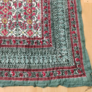 Può includere: Una trapunta con motivo floreale verde e rosso e un bordo decorativo. La trapunta è realizzata in cotone ed è morbida e confortevole.