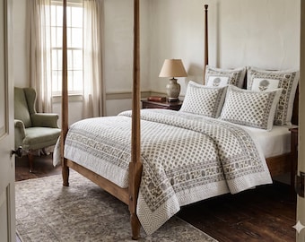 Può includere: Un letto a baldacchino in legno con una trapunta bianca e federe abbinate caratterizzate da un motivo floreale grigio stampato a blocchi. Il set di biancheria da letto include due cuscini quadrati con motivi floreali centrali e bordi geometrici.