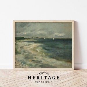 May include: A framed painting of a seascape with a sandy beach, a calm ocean, and a cloudy sky. Two sailboats are visible in the distance.