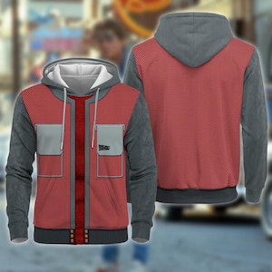 May include: A red and gray hoodie with a design inspired by the movie "Back to the Future." The hoodie features a red front with gray accents, including the sleeves, hood, and pockets. The front has two gray pockets and a vertical red stripe down the center. The "Back to the Future" logo is on the pocket.