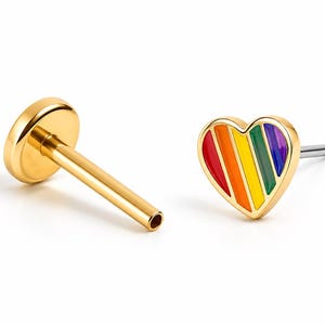 May include: A gold-toned flat back stud earring featuring a heart-shaped charm with diagonal stripes in red, orange, yellow, green, and purple enamel. The earring consists of a post with a circular base and a separate heart-shaped front piece.