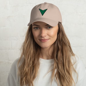 Puede incluir: Una gorra de béisbol beige con una flecha verde bordada en la parte delantera.