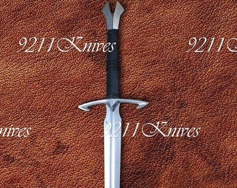 May include: A silver sword with a black handle, on a brown leather background. The text "9211 Knives" is visible on the image.
