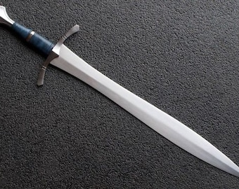 May include: A silver sword with a blue handle and a silver pommel. The sword is lying on a black textured surface.