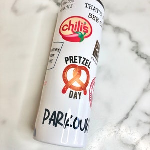 May include: White tumbler with various colorful logos and text, including "chili's", "Pretzel Day", "That's What She Said", and "Parkour".