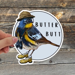 May include: A sticker featuring a cartoon bird wearing a safari hat and binoculars, with the text "BUTTER BUTT" below it.