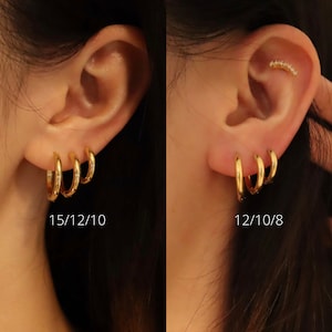May include: Three gold hoop earrings of different sizes, 15mm, 12mm, and 10mm, worn in a person's ear. The caption below the earrings reads "15/12/10".