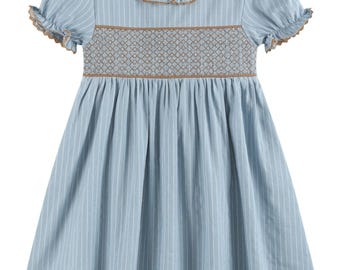 May include: A light blue dress with white vertical stripes, featuring a brown smocked bodice with a diamond pattern. The dress has short puff sleeves with ruffled edges and a round collar with a brown trim, creating a gathered skirt silhouette.